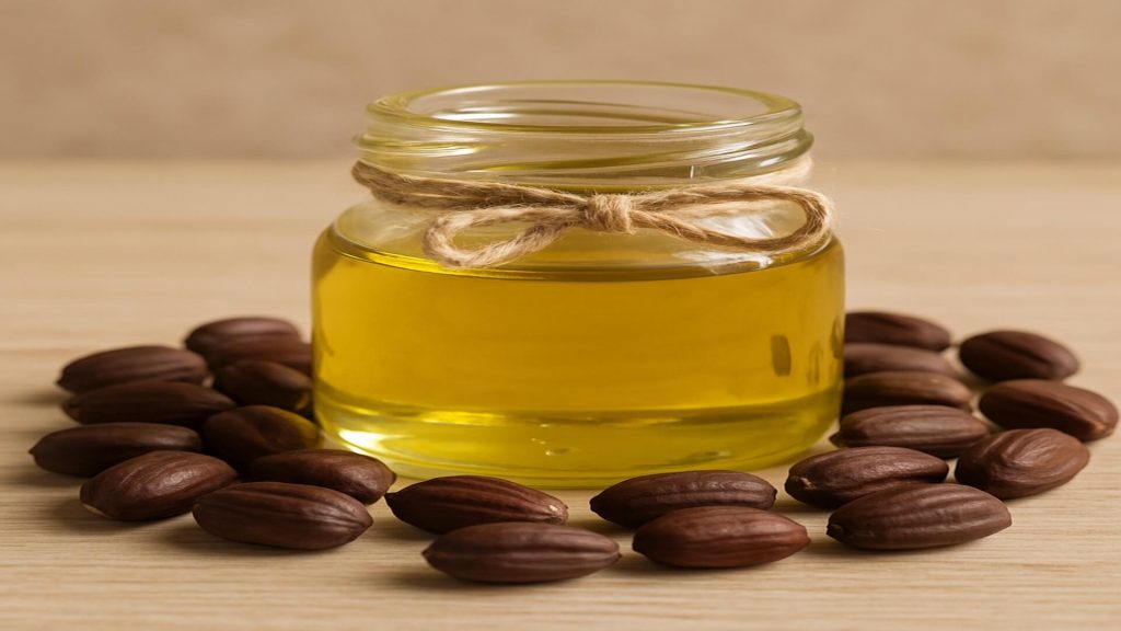 Jojoba oil in glass jar with jojoba seeds