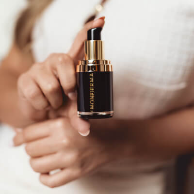 Woman holding and pointing at a Monderma custom formula class=